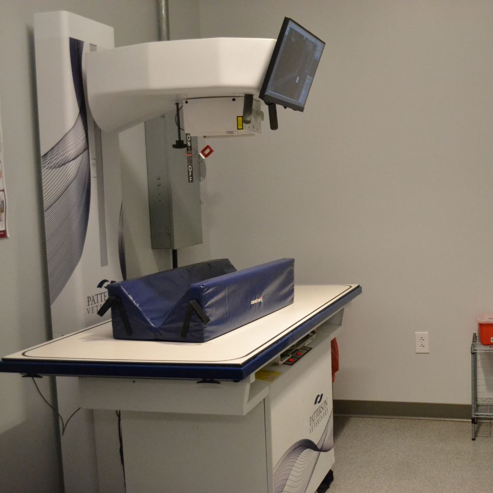 A medical machine stands in a room alongside a blue bag